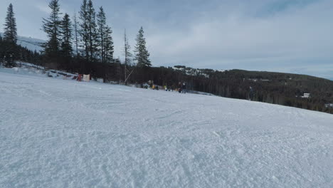 People-practicing-winter-sports,-skiing-or-snowboarding-in-a-mountain-covered-in-white-snow