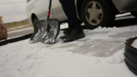 Man-shovels-part-of-his-driveway-after-a-snowfall