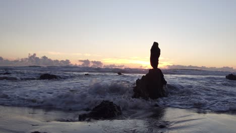 Atemberaubender-Blick-Auf-Den-Sonnenuntergang-Bei-Ebbe-Am-Laguna-Beach,-Während-Die-Sonne-Zwischen-Den-Felsen-Aufgeht-Und-Sich-Im-Wasser-Spiegelt
