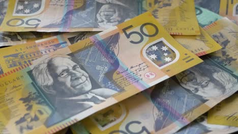 Close-up-of-Australian-money-falling-onto-table,-currency-falling
