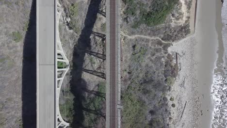 Aerial-Drone-Shot-of-Railway-and-Bridge-Next-to-the-Ocean-with-Crashing-Waves