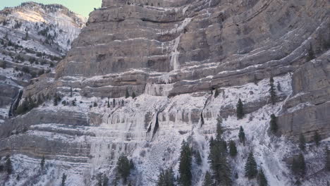 Luftaufnahme-Eines-Gefrorenen-Wasserfalls-Entlang-Einer-Scherklippe-In-Den-Rocky-Mountains