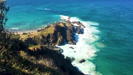 Byron-Bay-in-Australia-view-from-lighthouse-looking-down-at-crashing-waves-on-cliffs