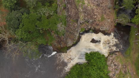 Birds-eye-view-spinning-aerial-shot-of-a-water-fall-in-the-East-African-jungle