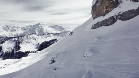 Aerial-drone-shot-on-montain-rock-in-the-alps,-Austria,-Kleinwalsertal,-skiing-area,-snowy-mountains