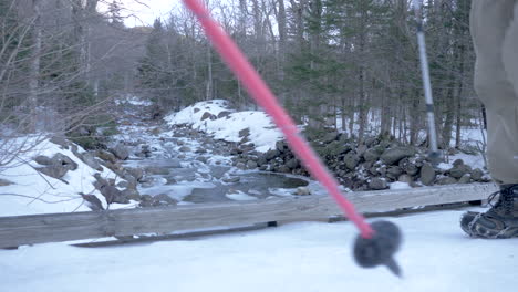 Two-Hikers-Crossing-a-Bridge-in-the-Woods-in-the-Middle-of-Winter-in-Slow-Motion