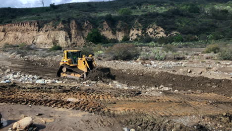 Bulldozers-grading-in-a-river-bed-after-a-storm-washed-out-the-road-Angle-5