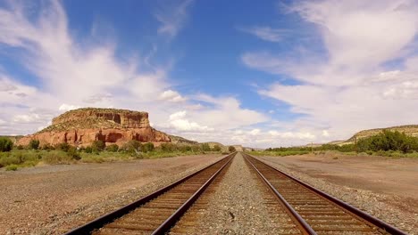 Die-Kamera-Fährt-Zurück-Und-Scannt-Langsam-Die-Schienen-Nach-Rechts-In-Die-Ferne,-In-Der-Wüste-Von-Arizona-Gibt-Es-Einen-Blauen-Himmel-Und-Bauschige-Weiße-Wolken