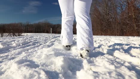 A-close-up-of-a-girl-walking-through-deep-snow