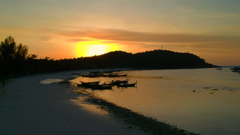 Luftaufnahme-Des-Strandes-Bei-Sonnenuntergang-Mit-Einem-Thailändischen-Boot