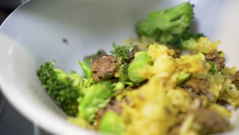 SLOWMO---Putting-food-curry-rice-with-broccoli-and-beef-mince-meat-in-bowl-to-serve