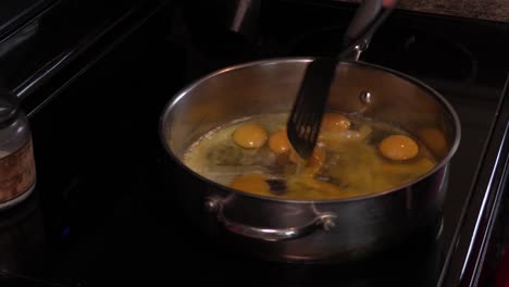 Young-Adult-Male-Scrambling-a-Large-Stainless-Steel-Pan-Full-of-Organic-Eggs