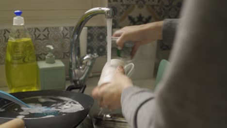 Close-Up-of-hands-washing-a-mug-with-a-sponge