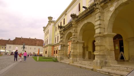 Wide-angle-shot-of-old-building-in-Alba-Iulia-Romanina-,-with-people-walking-in-the-background