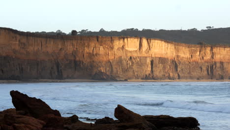 Morgensonne-Spiegelt-Sich-Auf-Der-Sandsteinfelswand-Eines-Erodierten-Australischen-Strandes