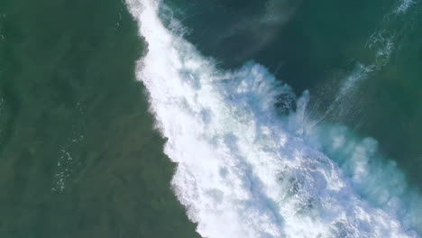 Aerial-cenital-cinematic-shot-of-a-surfer-surfing-a-big-tube-barrel-wave-that-creates-a-rainbow-in-Zicatela-beach-Puerto-Escondido,-Oaxaca