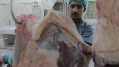 Close-up-panning-view-of-Workers-at-a-beef-processing-plant-and-sort-beef-parts,-They-covered-their-heads-at-working