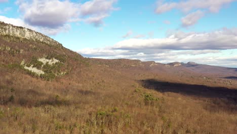 Drone-soars-by-cliffs-in-the-Catskill-Mountains-with-dramatic-cloud-shadows-on-the-forest-below