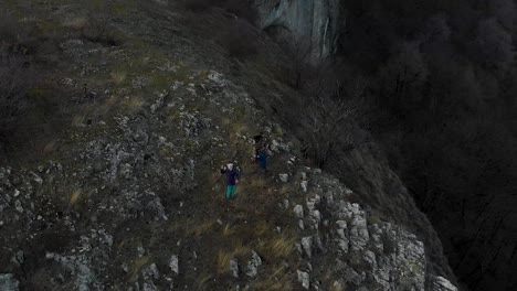 Children-play-on-edge-of-cliff---aerial-panning-shot
