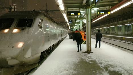 Snowing-and-Sandinavia-High-Speed-Train-Arriving-While-People-Waiting-at-Platform