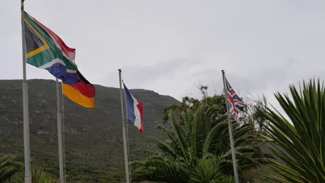 Flaggen-Von-Südafrika,-Deutschland,-Frankreich-Und-Großbritannien-Flattern-Bei-Starkem-Wind-Am-Cape-Point,-Südafrika