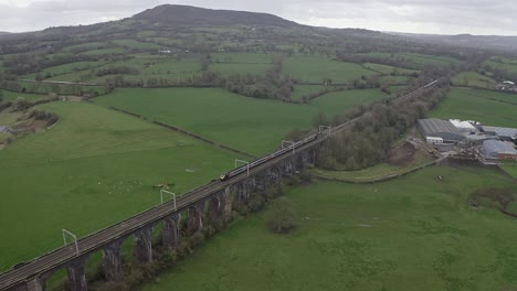 An-aerial-view-of-the-a-large-Buxton-railway-bridge-viaduct-in-the-Derbyshire-Peak-District-national-park,-a-busy-train-track-in-the-beautiful-Derbyshire-countryside,-Aerial-photography