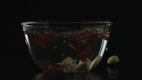 Slow-Motion-of-Garlic-Dropping-in-Bowl-of-Water-and-Chili