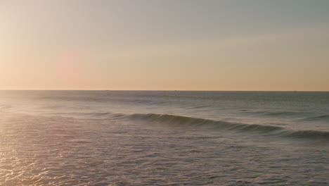 Kleine-Wellen-Brechen-Während-Eines-Ruhigen-Sonnenaufgangs-In-Luz,-Portugal