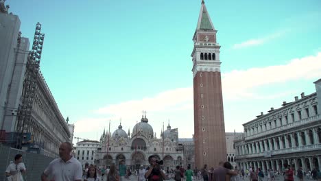 Closeup-shot-of-St-Mark's-Campanile,-with-tourists-enjoying-the-square-in-Venice,-Italy