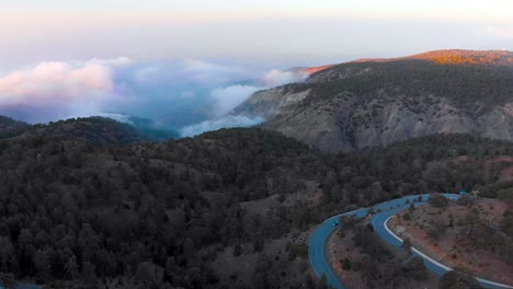 Aerial-shot-flying-over-the-cloudy-mountain-range-of-Mount-Olympus-with-roadway