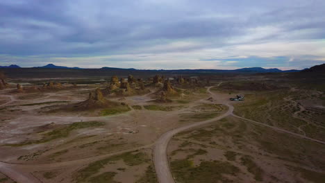 Aerial-footage-of-drone-flying-towards-Trona-Pinnacles,-campers-seen-in-the-background