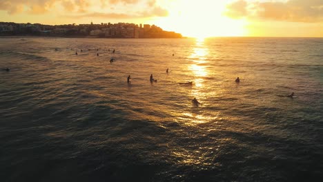 Static-aerial-shot-of-several-surfers-at-Bondi-Beach-during-Sunrise