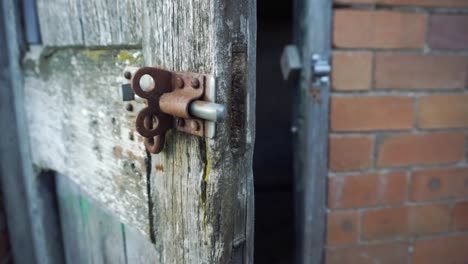 Pan-around-rusted-bolt-and-creaky-old-wooden-door