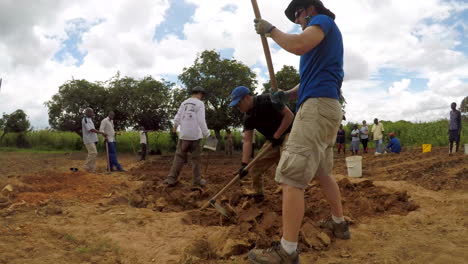 Time-Lapse-of-Americans-on-a-Missions-Trip-Using-Hoes-to-Break-Ground-on-a-New-Garden-in-Rural-Zimbabwe,-Africa