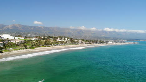 Aerial-drone-shot-over-the-white-sand-and-blue-ocean-water-of-Leadbetter-Beach-in-Santa-Barbara,-California