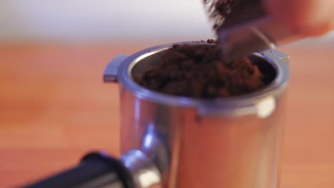 Putting-the-freshly-ground-coffee-inside-the-porta-filter-macro-shot