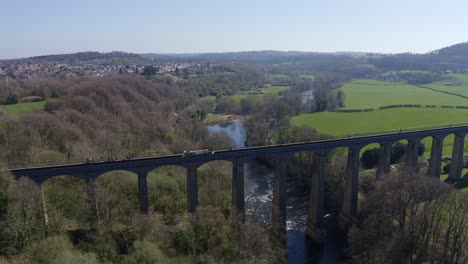 A-Narrow-Boat,-canal-boat-crossing-the-Pontcysyllte-Aqueduct,-designed-by-Thomas-Telford,-located-in-the-beautiful-Welsh-countryside,-famous-Llangollen-Canal-route,-as-walkers-make-their-way-across