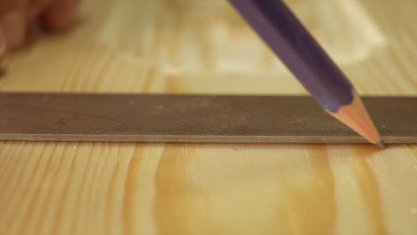 Eine-Makroaufnahme-Eines-Tischlers,-Der-Einen-Bleistift-Und-Ein-Hartholzquadrat-Auf-Einem-Stück-Holz-Verwendet