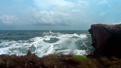 slow-motion-low-angle-view-of-wave-splashing-against-reefs-in-the-Caribbean,-Tortuguilla,-Colon,-Panama
