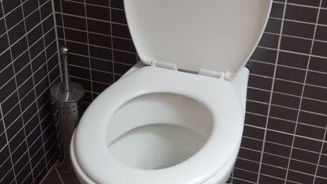 Toilettenschüssel,-Toilette-Im-Modernen-Badezimmer-Mit-Schwarzen-Und-Grauen-Fliesen,-HD-1080p,-Offener-Deckel,-Kranaufnahme