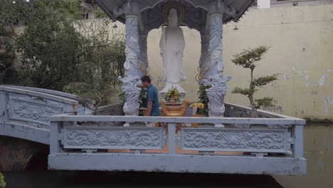 Aufnahme-Eines-Mannes,-Nachdem-Er-Sein-Gebet-Vor-Einer-Wunderschönen-Weißen-Buddha-Statue-In-Einem-Pavillon-Eines-Buddhistischen-Tempels-Beendet-Hat