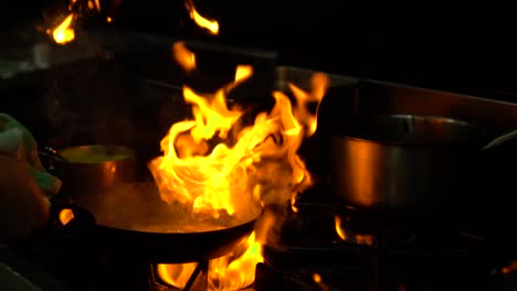 SLOWMO---Chef-in-a-luxury-restaurant-kitchen-flame-frying-seafood---CLOSE-UP