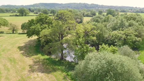 Drone-Volando-Sobre-Tierras-Agrícolas-En-Cheshire,-Reino-Unido,-Cerca-Del-Borde-De-Alderley-Y-Mostrando-Un-Estanque-Natural