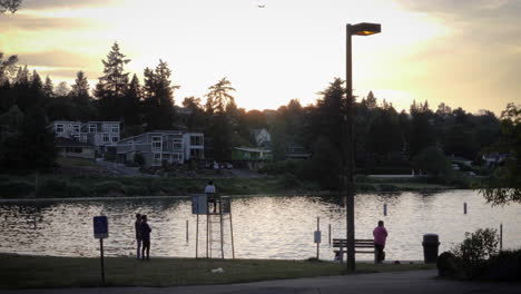 Weitwinkelaufnahme-Von-Menschen,-Die-Sich-Bei-Sonnenuntergang-Am-Ufer-Des-Lake-Washington-Aufhalten