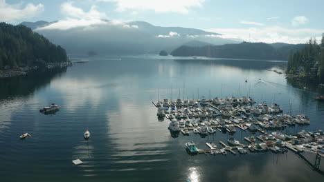 Drone-view-of-a-marina,-tilting-up-to-reveal-a-mountain-in-the-distance