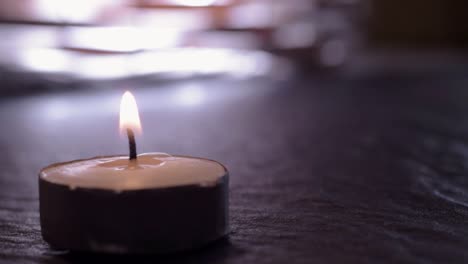 Lit-candle-flickers-on-background