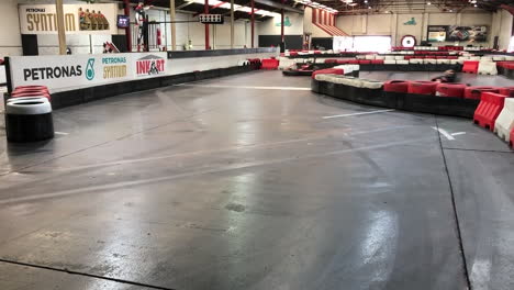 Kids-driving-by-and-saluting-in-carts-on-an-indoor-race-circuit