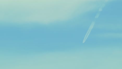 Eine-Strahlspur-Am-Blauen-Himmel-Mit-Wolken,-Mittlere-Aufnahme-Aus-Der-Ferne