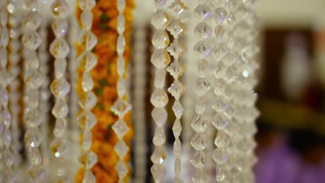Crystal-Clear-Acrylic-Bead-Hanging-wedding-supplies-Line-Chain-around-marry-gold-flowers,-Close-Up