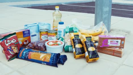 Packaged-food-in-plastic-wrapping-laid-out-on-concrete